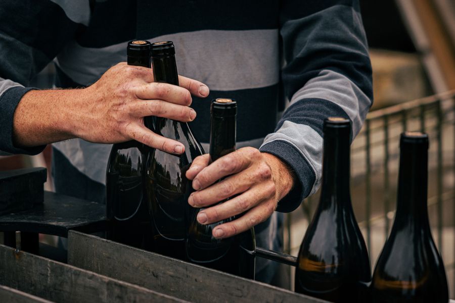 Un vigneron range des bouteilles de vin en Nouvelle-Aquitaine
